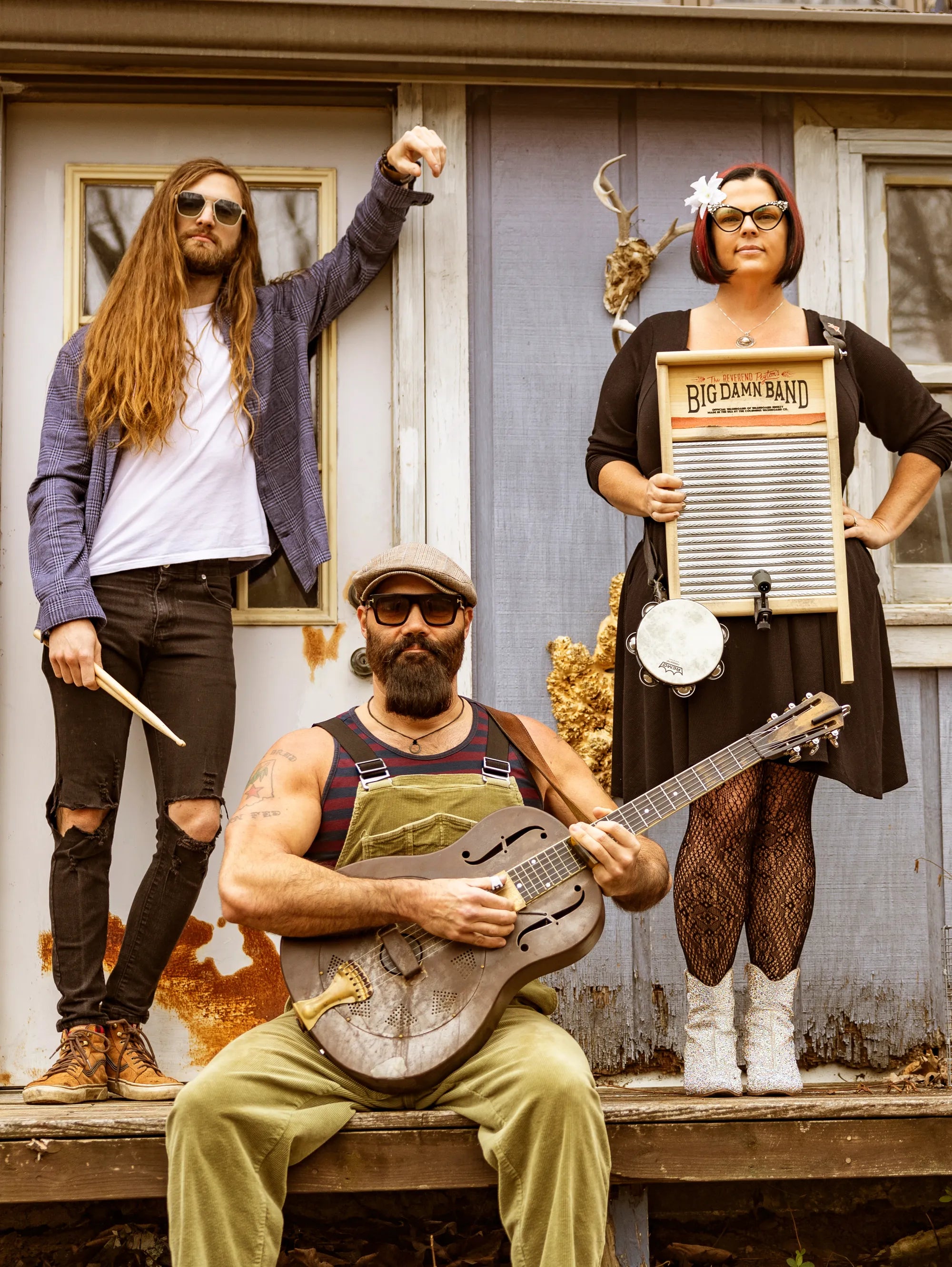 Three people in a rustic setting with musical instruments